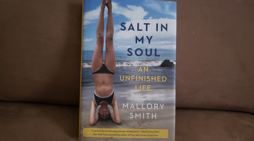 A hardback copy of Salt in My Soul is propped up on a brown couch cushion