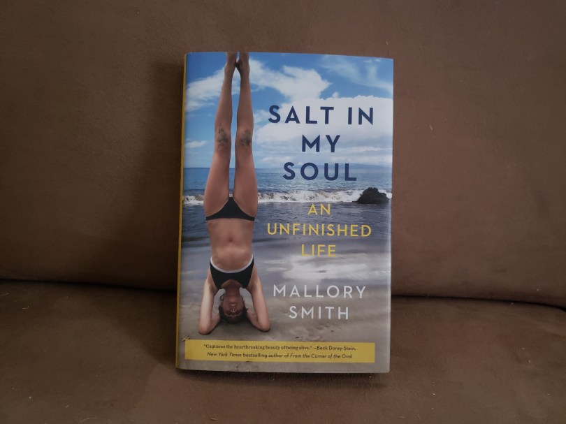 A hardback copy of Salt in My Soul is propped up on a brown couch cushion